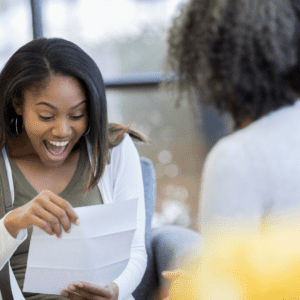 high school girl excitedly reads scholarship letter from college after getting goal act score 